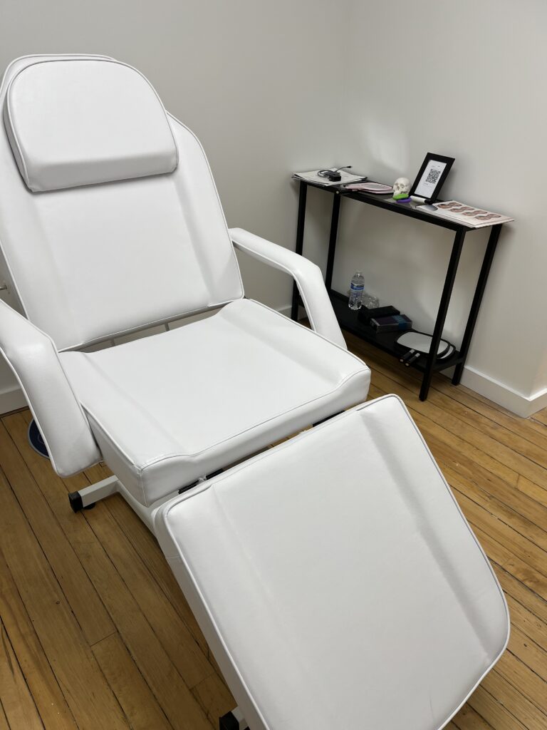 A pristine white treatment chair in a room at Vitality Lounge Med Spa.