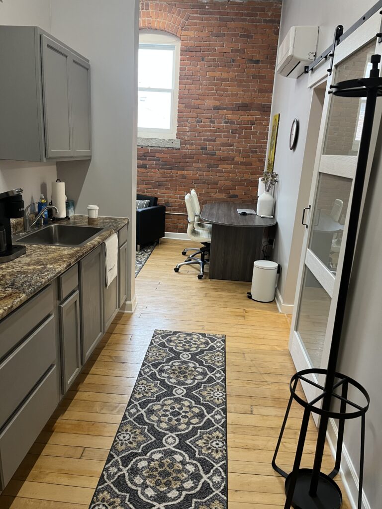 A kitchenette hallway leading to the waiting area at Vitality Lounge Med Spa.